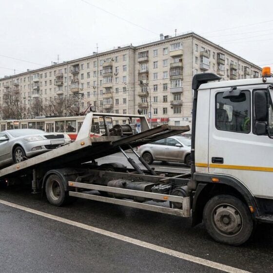 Услуги эвакуатора в Москве — эвакуатор грузит легковой автомобиль на платформу